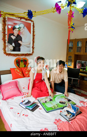 Newly wed couple chinois dans leur chambre à la recherche de photo de mariage album JMH2933 Banque D'Images