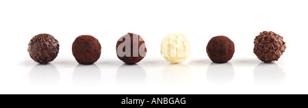 Ligne d'un assortiment de truffes au chocolat sur fond blanc Banque D'Images