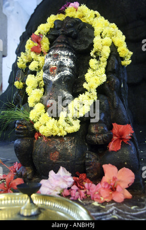 Tout enguirlandés un statue de Ganesha dans le Bull Temple dans le quartier Basavanagudi de Bangalore. Ganesha est le dieu de la sagesse. Banque D'Images