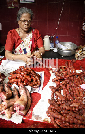 Une femme vend des biens produits localement dans le Marché Municipal de Goa. Les saucisses rouges sont très similaires à l'chaurisso ou de chorizo. Banque D'Images