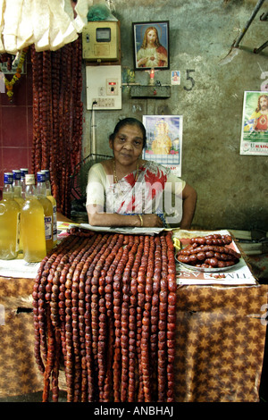 Une femme vend des biens produits localement dans le Marché Municipal de Goa. Les saucisses rouges sont très similaires à l'chaurisso ou de chorizo. Banque D'Images