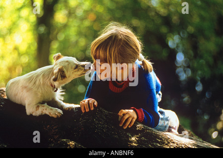 Mixed-breed dog licking girls face Banque D'Images