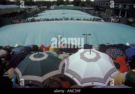 Wimbledon pluie couvre les fans attendent le mauvais temps pour améliorer les arrêts de pluie jouer Wimbledon tennis Londres SW19 1980s Royaume-Uni. 1985 HOMER SYKES Banque D'Images