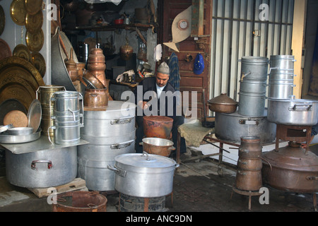 Homme berbère la fabrication et la vente d'ustensiles de cuisine dans un souk à Meknès, Maroc, Afrique du Nord Banque D'Images