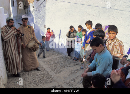 Musiciens portant des djellabas et des enfants à Medina Chechaouen Maroc Banque D'Images