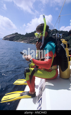 Les plongeurs de faire un pas de géant pour entrer dans l'eau en Thaïlande à partir d'un yacht dans le parc national des îles Similan Banque D'Images