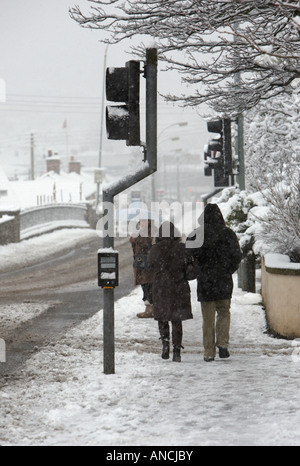 Couple walking down sentier couvert de neige Banque D'Images