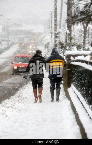 Couple walking down sentier couvert de neige Banque D'Images