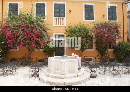 Petite fille à la recherche dans le monde et sur la place de la Panagia Kremasti. La vieille ville de Kerkyra, Corfou, Grèce. Banque D'Images