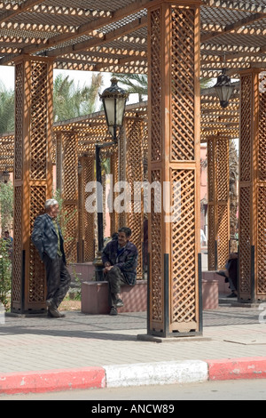 Deux hommes en conversation sous ombrage marrakesch Banque D'Images