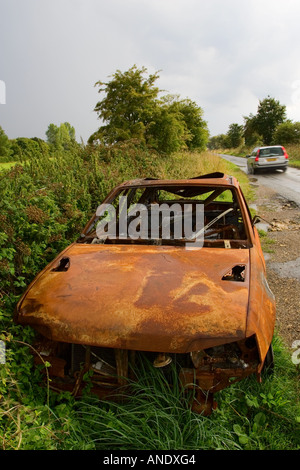 Carcasse de voiture brûlée sur la route France Banque D'Images