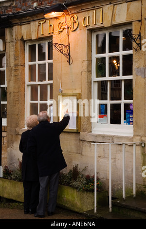 Lire Couple menu du pub et restaurant Bull Burford Cotswolds dans l'Oxfordshire, UK Banque D'Images