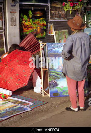 Artiste de rue femme afficher des tableaux colorés à l'extérieur du marché Anusan trottoir occupée Chiang Mai Thaïlande Asie du sud-est Banque D'Images