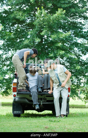 Les randonneurs d'entrer dans l'arrière du camion pick-up Banque D'Images