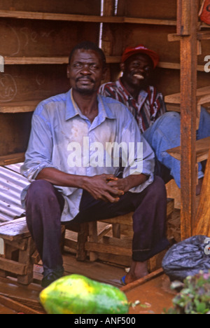 Paire de colporteur Africain noir hommes posant fièrement à l'intérieur de leur décrochage en bois mobile Dar es Salaam Tanzanie Afrique de l'Est Banque D'Images