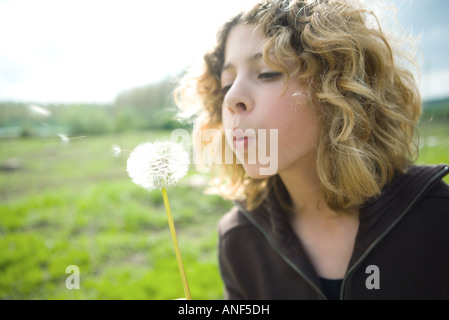 Teen girl blowing dandelion seeds Banque D'Images