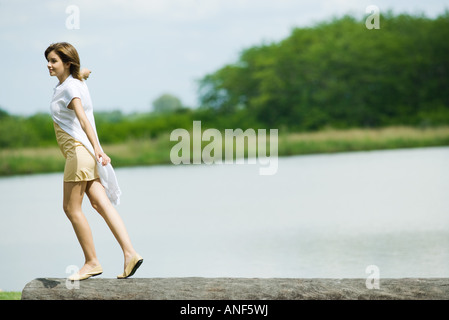 Young woman walking along haut de log Banque D'Images