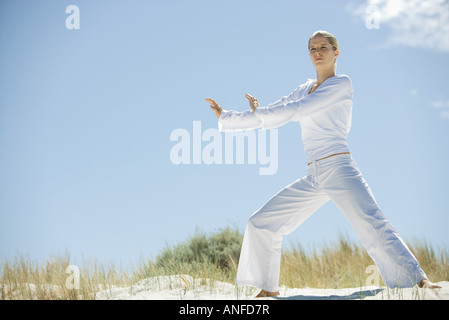 Young woman doing Yoga en dunes, pleine longueur Banque D'Images