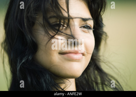 Jeune femme avec les cheveux sur son visage, smiling, portrait Banque D'Images