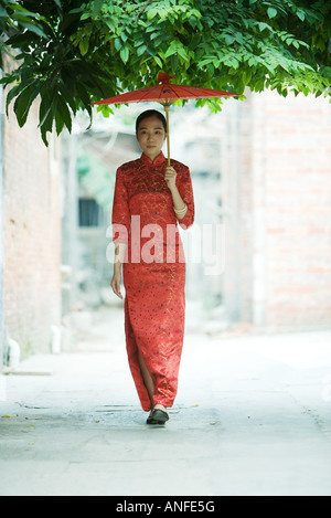Jeune femme portant des vêtements traditionnels chinois, avec un parasol de marche Banque D'Images