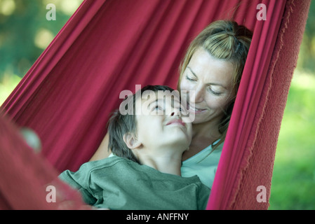 Mère et enfant dans un hamac, smiling at each other Banque D'Images