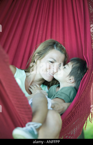Mère et enfant dans un hamac, boy kissing woman's face Banque D'Images