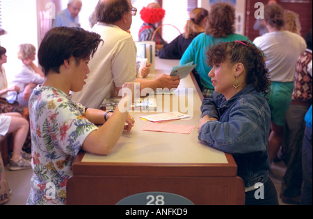 L'âge de 16 ans d'amis converser dans la langue des signes à la bibliothèque publique. Merriam Park Library St Paul Minnesota USA Banque D'Images