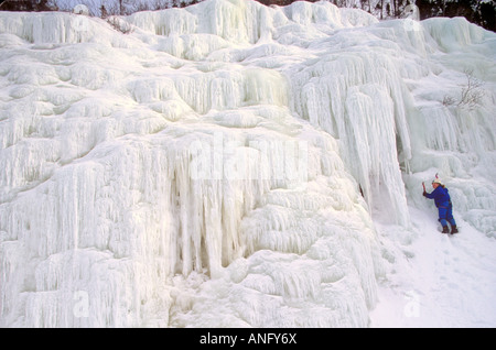 Ice Climber scaling mur glacé de Baker's Brook Pond, le parc national du Gros-Morne, à Terre-Neuve, Canada. Banque D'Images