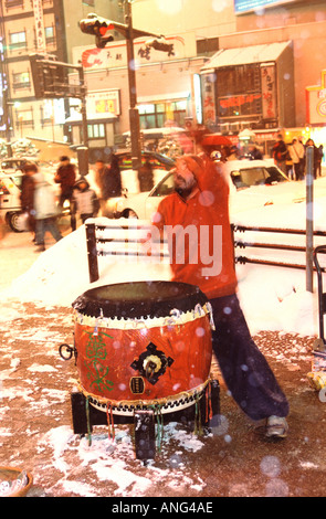 Un batteur busks tard dans la nuit dans la neige dans le quartier des divertissements de Susukino, à Sapporo, Hokkaido, Japon Banque D'Images