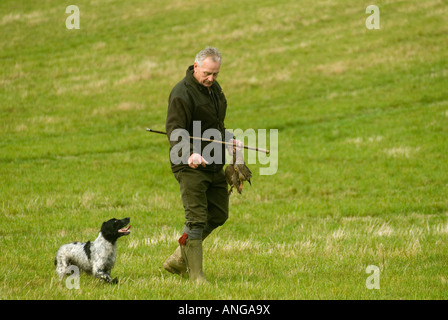 D'OISEAUX jeux de tir shoot St Claire s Estate Hampshire Angleterre l'homme et le chien retriever picker upper 2000s HOMER SYKES Banque D'Images