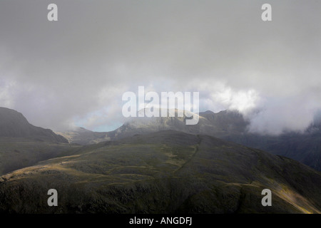 La brume et nuage tourbillonnant autour de Scafell Pike et Scafell de pilier au-dessus de Rivamonte Agordino et à la tête de Ennerdale Lake District Cumbria England Banque D'Images