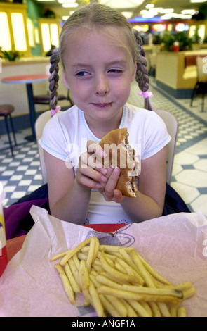 Jeune fille mange un burger UK Banque D'Images