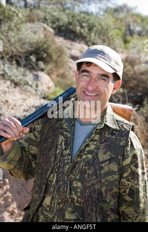 Un tir de chasse aux oiseaux migrateurs de printemps de chasseur chypriote avec un fusil de chasse ; tir et chasse aux oiseaux chanteurs dans la péninsule d'Akamas, à Pafos, à Chypre, Banque D'Images