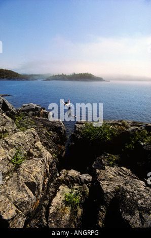 Man jumping rochers le long de la côte de Terre-Neuve, Canada. Banque D'Images