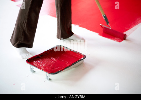 31 ans femme italienne peinture rouge sur un mur blanc dans un loft, Montréal, Québec, Canada. Banque D'Images