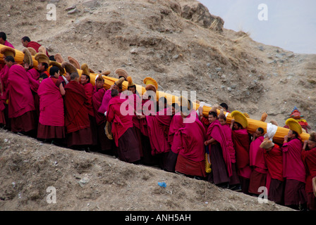 Une longue lignée de moines est un carrieng Tanka énorme d'un monastère de Labrang dans this page ministry strategy dans le Qinghai province Chine Banque D'Images