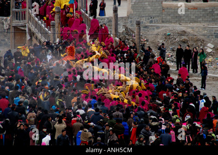 Une longue lignée de moines est un carrieng Tanka énorme d'un monastère de Labrang dans this page ministry strategy dans le Qinghai province Chine Banque D'Images