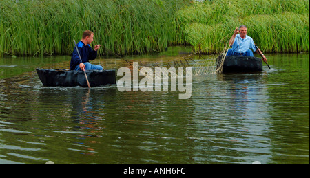 La pêche au filet à l'aide de deux coracles sur un lac au Pays de Galles Banque D'Images