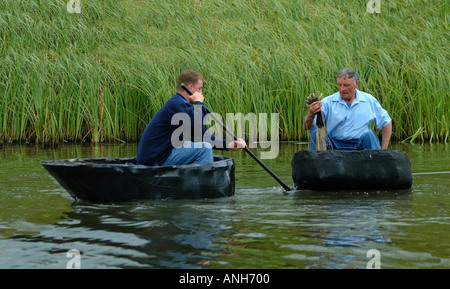 La pêche au filet à l'aide de deux coracles sur un lac au Pays de Galles Banque D'Images