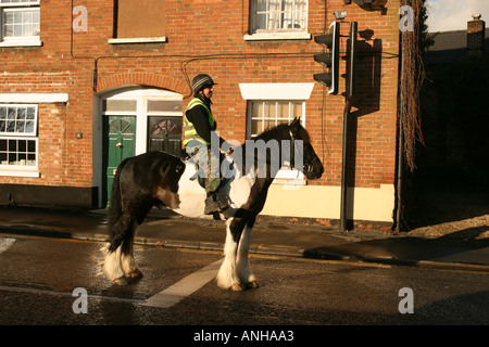 Grand Shire Horse Rider et attendre que les feux rouges sur la route principale dans le Wiltshire Highworth Banque D'Images