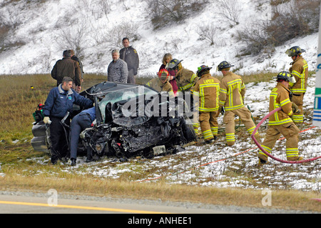 Les pompiers blessés à assister à l'égard des victimes d'accidents d'un chef sur l'accident automobile Banque D'Images