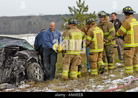 Les pompiers blessés à assister à l'égard des victimes d'accidents d'un chef sur l'accident automobile Banque D'Images