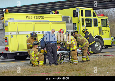 Les pompiers blessés à assister à l'égard des victimes d'accidents d'un chef sur l'accident automobile Banque D'Images