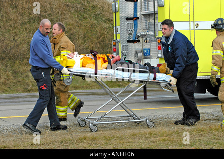 Les pompiers blessés à assister à l'égard des victimes d'accidents d'un chef sur l'accident automobile Banque D'Images