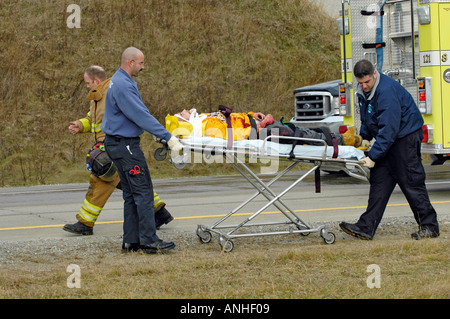 Les pompiers blessés à assister à l'égard des victimes d'accidents d'un chef sur l'accident automobile Banque D'Images