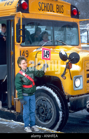 Patrouille élémentaire boy supervise l'embarquement d'un autobus scolaire par des étudiants Banque D'Images