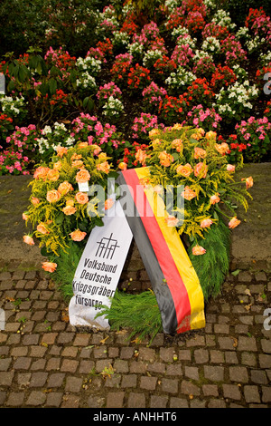 Fleurs sur le charnier au cimetière militaire allemand de Langemark de WW1 soldats près de Ypres en Belgique Banque D'Images