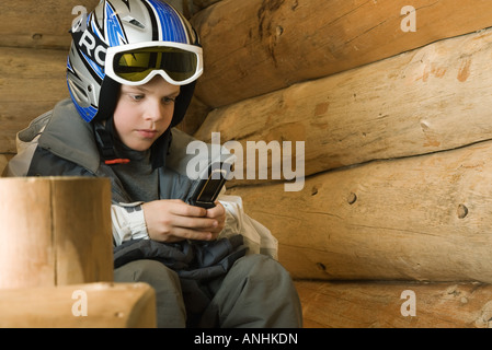 Boy in ski gear using cell phone Banque D'Images