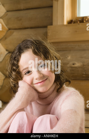 Fille assise à genoux, smiling at camera Banque D'Images