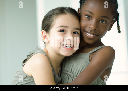 Deux jeunes amis féminins enlacés, les deux smiling at camera Banque D'Images